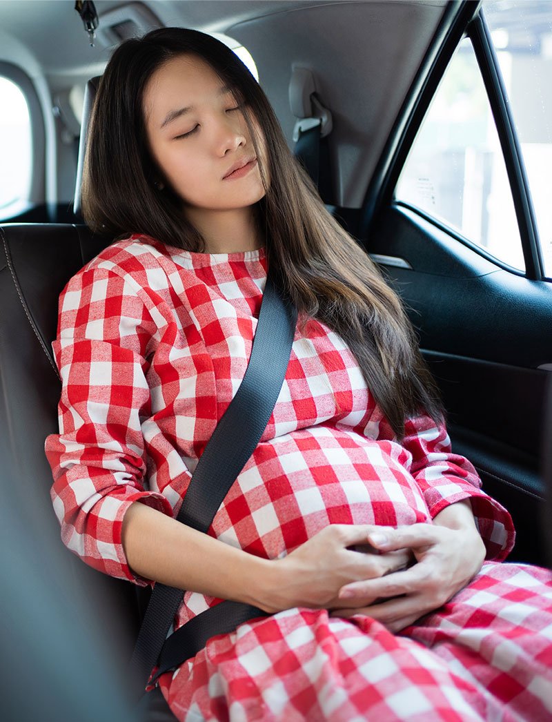 Femme enceinte se reposant dans une voiture